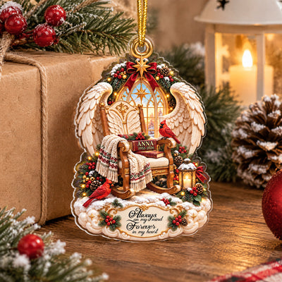 Personalized Angel Wings Memorial Acrylic Ornament standing on a wood table by a gift box, candle lantern and pinecone
