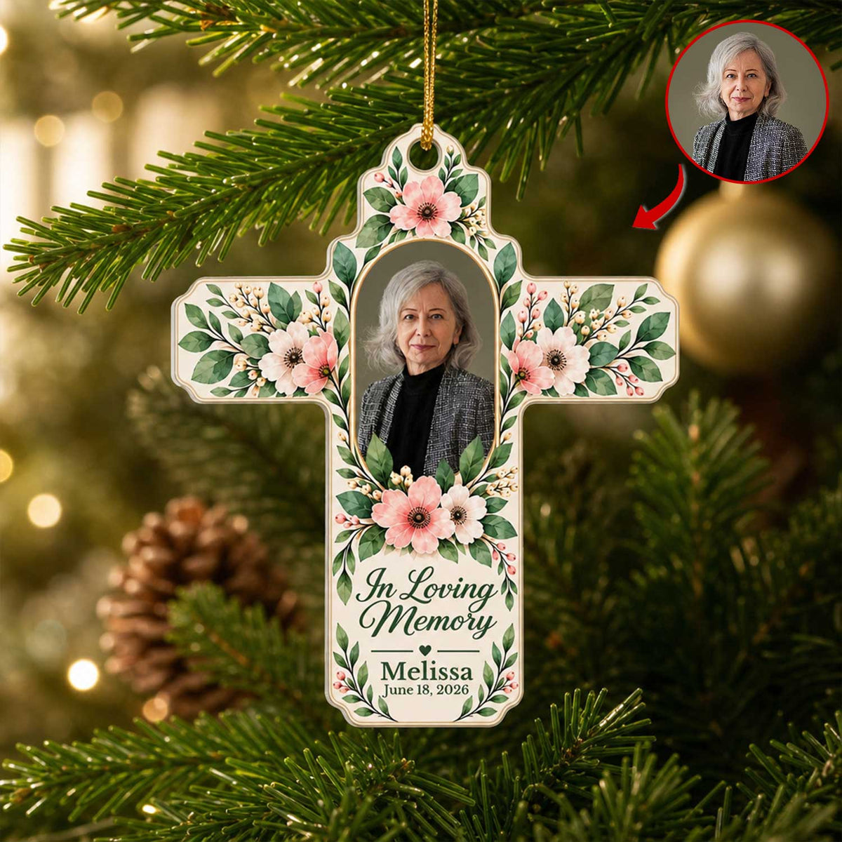 Personalized Floral Cross Acrylic Ornament hanging on a pine branch with a gold ball, photo of a gray-haired woman