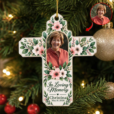 Personalized Floral Cross Acrylic Ornament on a lit Christmas tree, smiling woman in a red top, with photo inset
