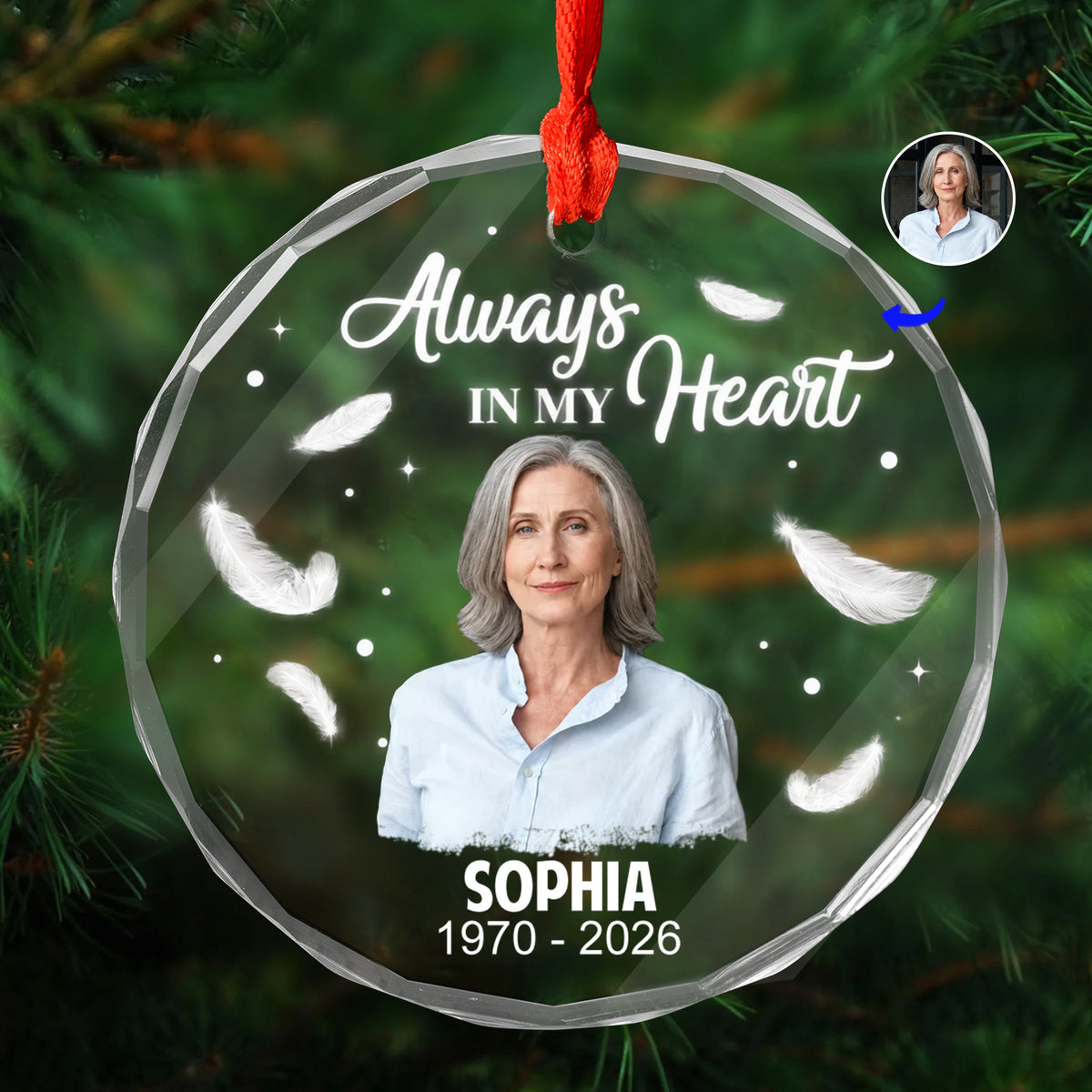 Personalized Glass Ornament Always In My Heart with woman's photo, feathers and name, on a pine branch with red ribbon