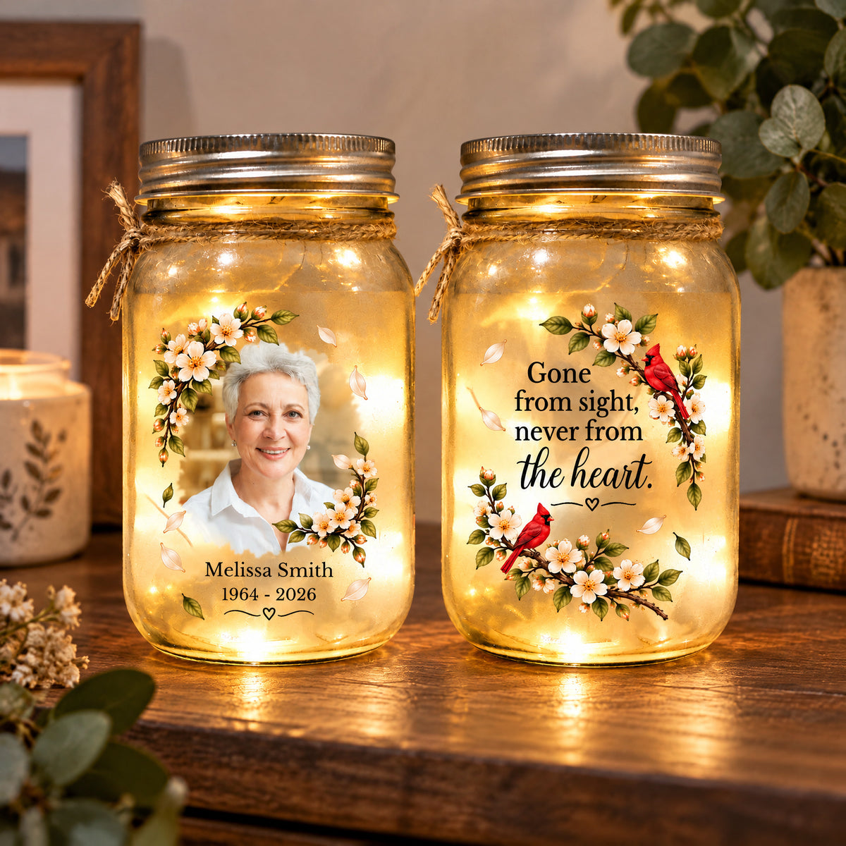 Personalized Mason Jar Light pair on a shelf beside a candle and plant, with flowers, cardinals and a portrait